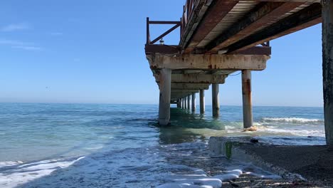 Filmado-Bajo-Un-Muelle-En-La-Costa-Sur-De-España,-Lapso-De-Tiempo-De-Vacaciones-En-El-Mar-Español-Del-Mar-Moviéndose-Bajo-El-Muelle