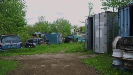 Wide-shot-of-a-group-of-abandoned-cars-left-to-rust-away-in-the-trees