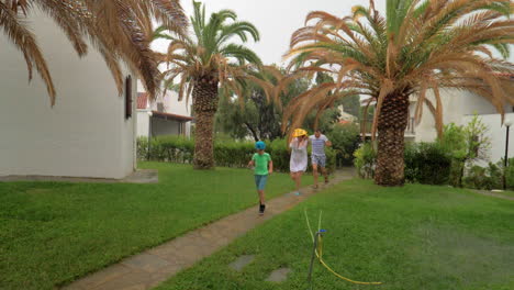 parents and child running in the yard under rain