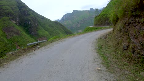 first person view of a narrow winding rough road that cuts through the mountains and valleys of northern vietnam