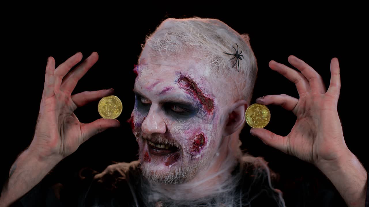 hombre espeluznante con cicatrices sangrientas cara, halloween zombie mostrando bitcoins de oro minería tecnología del futuro