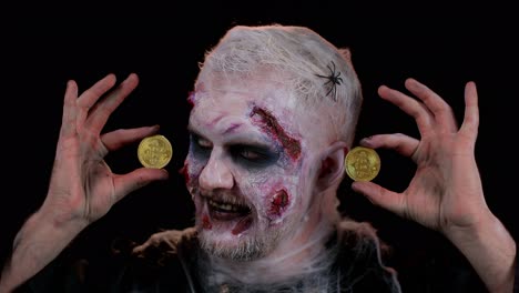 Creepy-man-with-bloody-scars-face,-Halloween-zombie-showing-golden-bitcoins-mining-future-technology