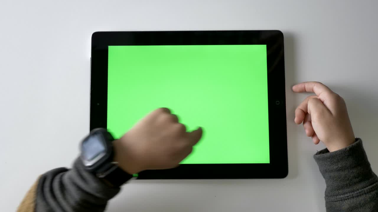 Children's hands swiping on a tablet, Green screen, chromakey concept, Top shot 60 fps