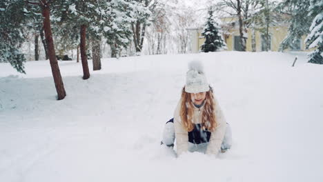 pretty girl is playing with snow in the park in winter. active kid throws up white snow and has a lot of fun with it outdoors. slow motion.