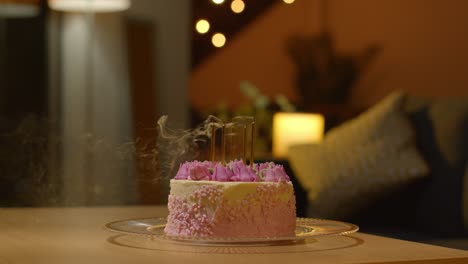 Candles-Being-Blown-Out-On-Party-Celebration-Cake-For-Birthday-Decorated-With-Icing-On-Table-At-Home