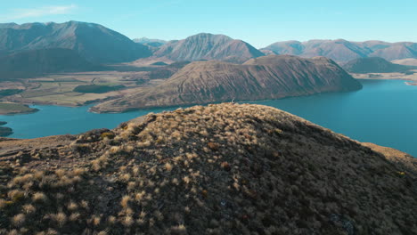 man walks down mountain hiking trail towards lake coleridge in scenic canterbury new zealand