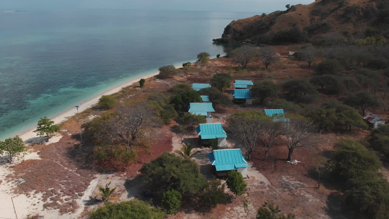 toma aérea de drones de los techos de la casa de la isla rodeada de increíbles aguas turquesas del océano con arrecifes de coral y naturaleza