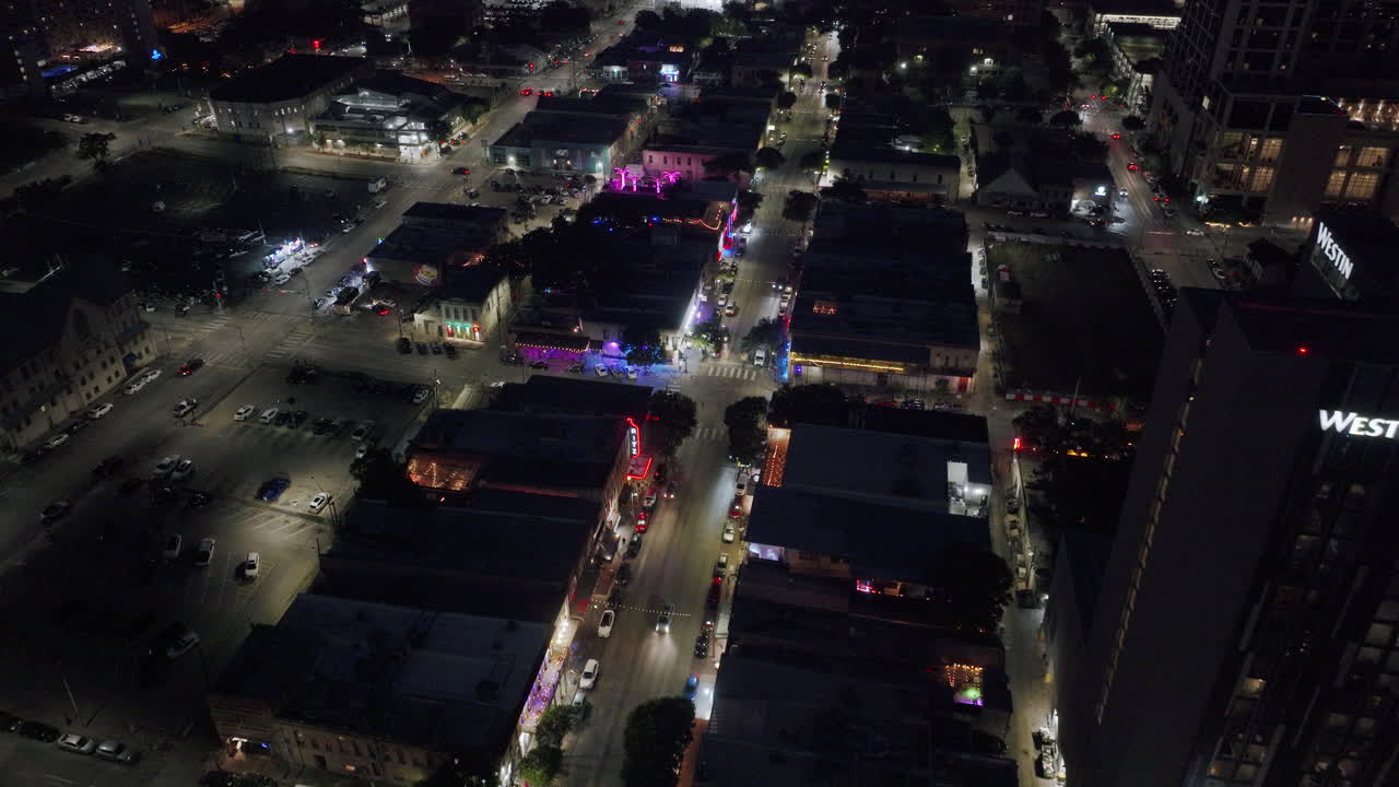 Aerial Night View of a Lively City Street with Illuminated Buildings and Traffic