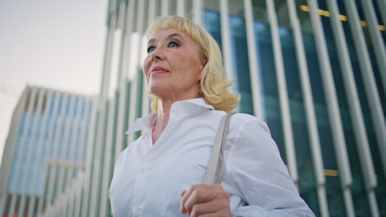 старшая бизнесменка позирует на городской улице вблизи. элегантная пожилая леди стоит