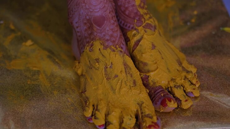 Turmeric Paste On Bride's Feet During Pithi Ceremony Celebration - Close Up