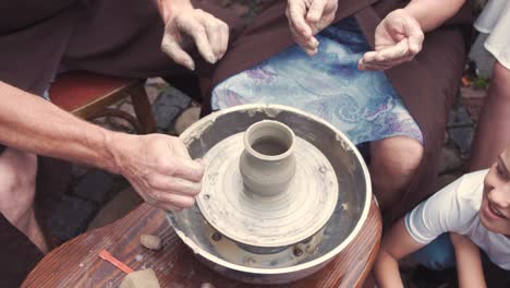 grandmother with a grandchildren make pitchers in pottery