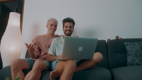 two men watching something on a laptop at home