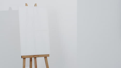 video of white canvas sign on wooden easel with copy space on white background