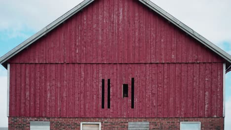 person dismantle wooden pallet walls of an old barn house