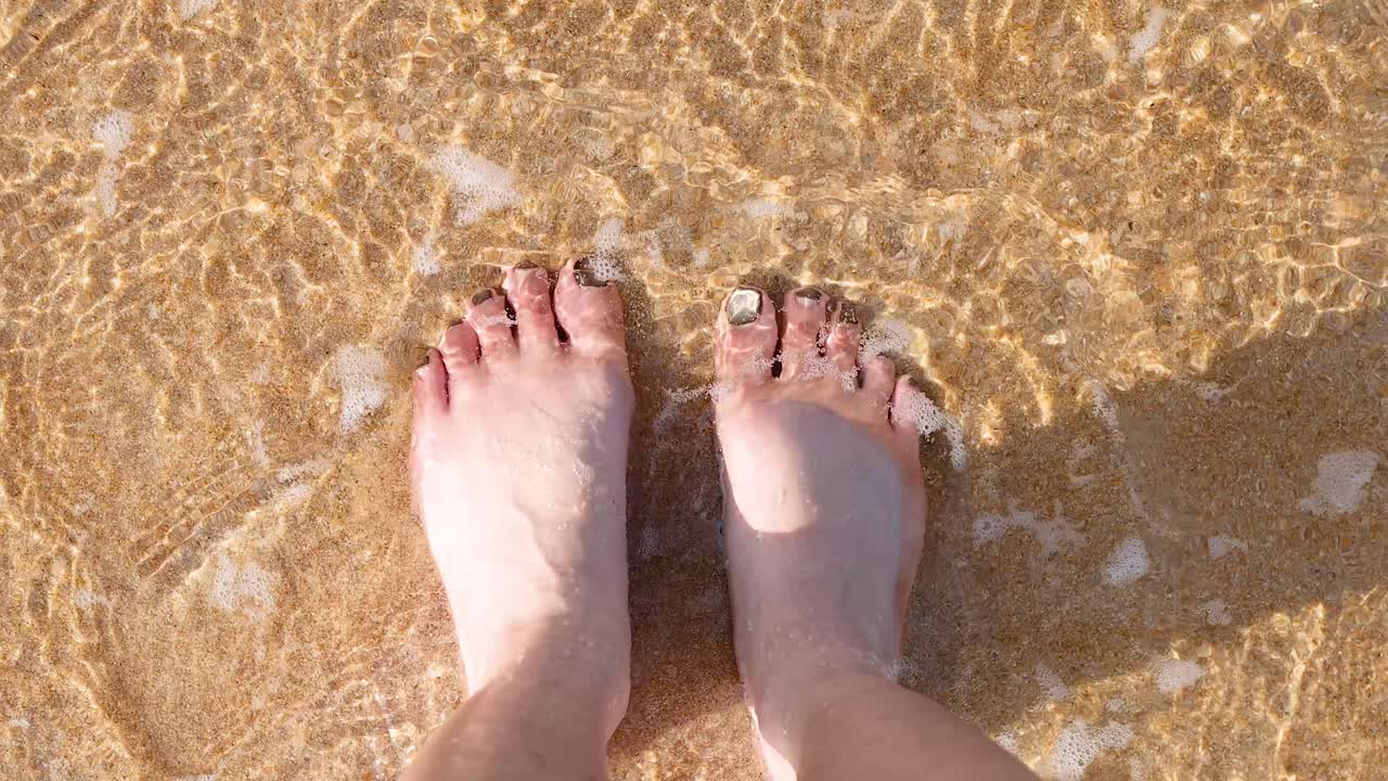 모래 해변 에서 부드러운 파도 를 즐기는 발