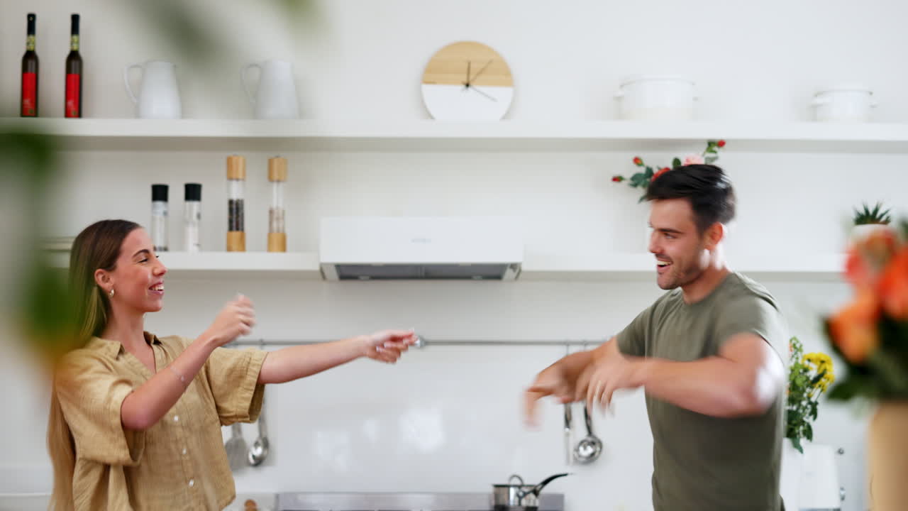 Energy, happy and couple dance in the kitchen to