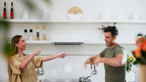 energy, happy and couple dance in the kitchen to