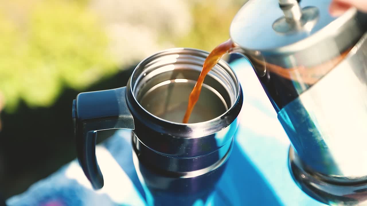 la prensa francesa comienza a verter café o té en un termo en la cima de una montaña tomada en cámara súper lenta de 4k