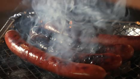 Grilling-sausages-on-disposable-barbecue-grid.