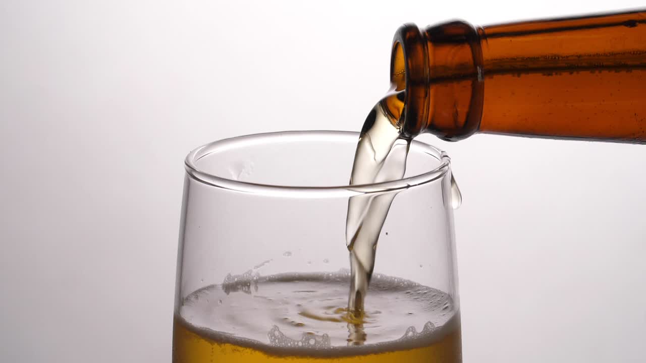 Beer Being Poured Into Translucent Glass, Slow Motion