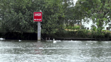 red warning board on the river thames flowing through royal windsor in england