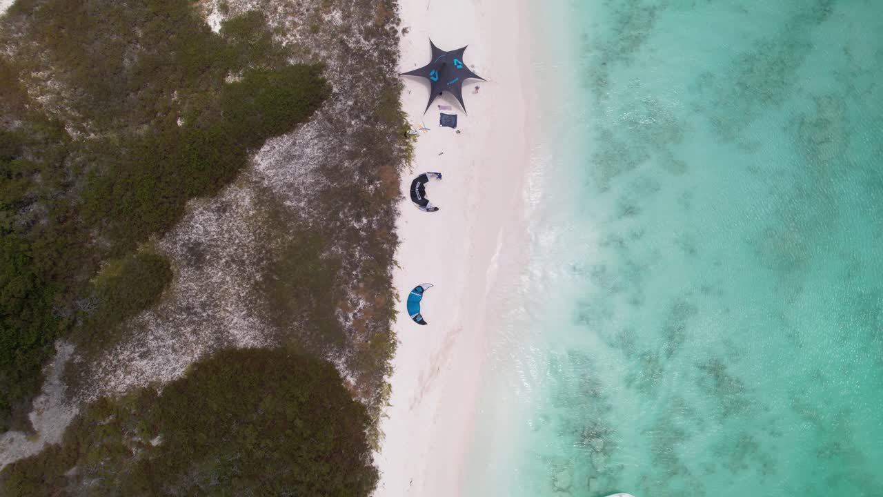 vista a vista de pájaro de cometas, toldos de campamento y surfistas en la isla de crasqui, los rocas