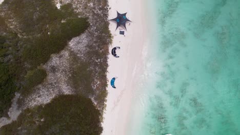 birdseye view of kites, camp awnings and surfers at crasqui island, los roques