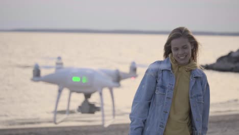 young girl making video on the beach using drone