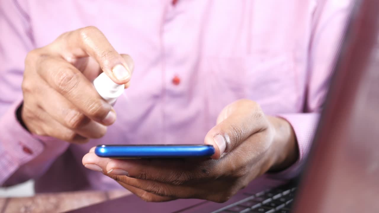 limpieza de un teléfono inteligente con desinfectante de manos