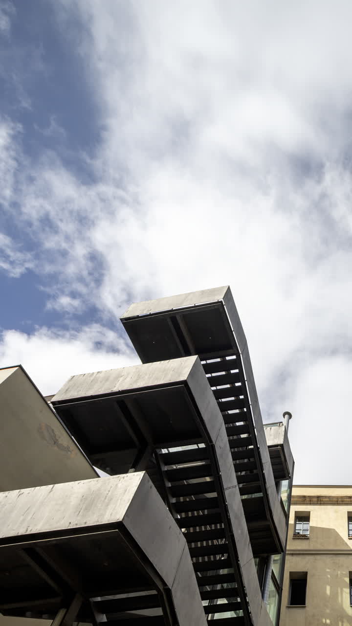 Old factory chimney and apartment buildings in barcelona in vertical