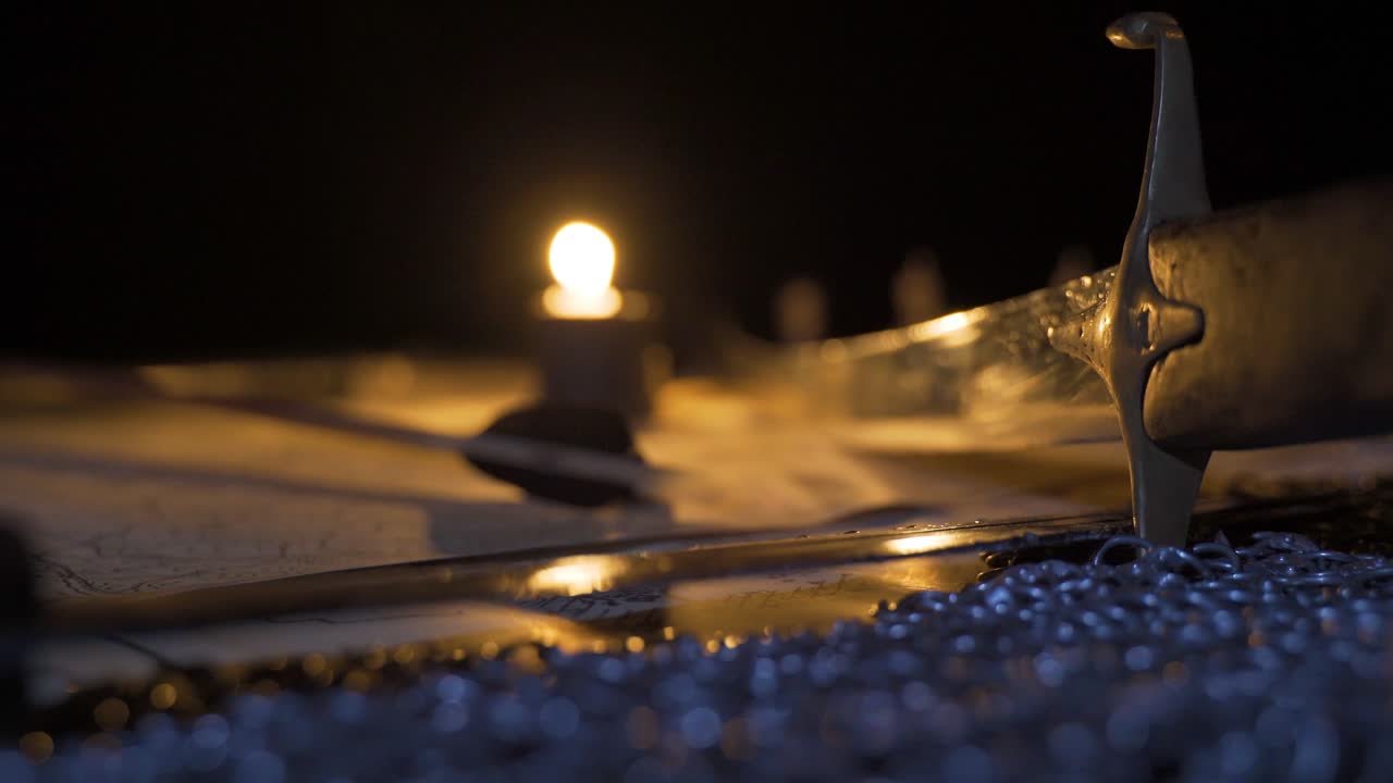 espada de guerra medieval y mapa a la luz de las velas.