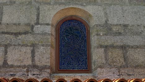 stained glass window in a stone wall