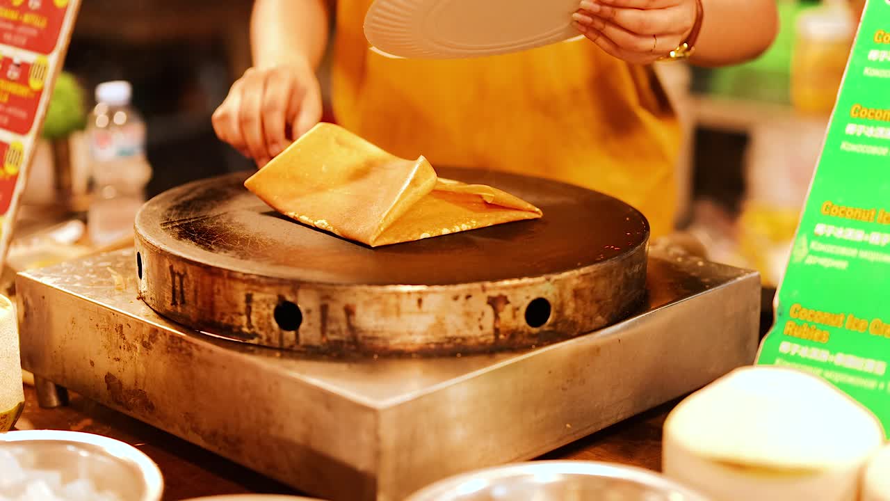 vendedor preparando crepes de plátano en el puesto del mercado de comida callejera de phuket