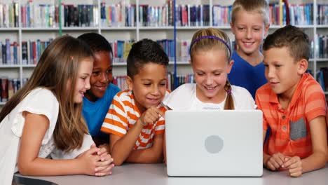 school kids using laptop in library