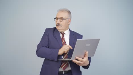 hombre de negocios mirando la computadora portátil con expresión asustada.