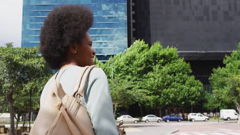 african american businesswoman walking and waving hand