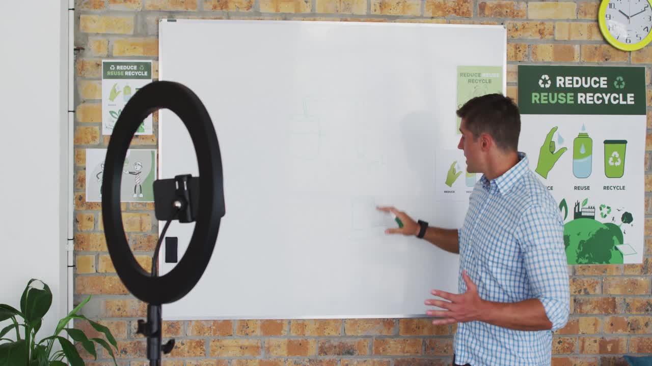 profesor masculino caucásico de pie en la pizarra dando una lección en línea a la cámara