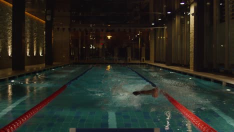 swimmer in indoor pool at night