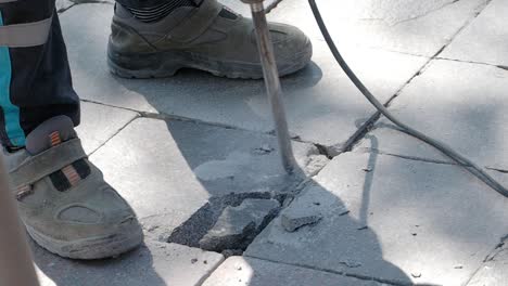 repairing damaged pavement with jackhammer