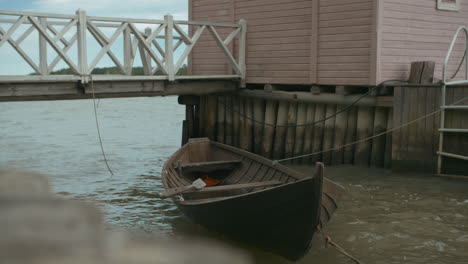 wooden rowing boat next to small beach hut