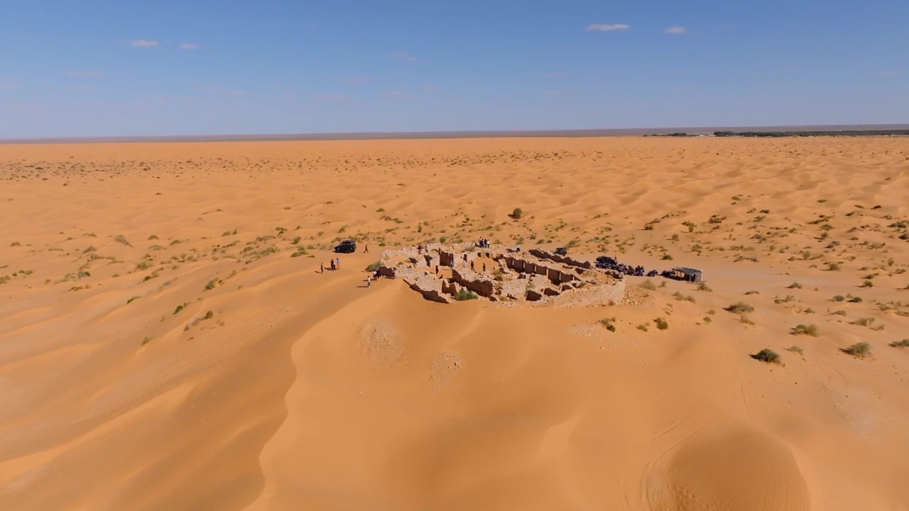Ripresa aerea con drone delle rovine dello storico Forte Tisavar, circondate dalle sabbie dorate del Sahara che conducono verso l'Oasi di Ksar Ghilane in Tunisia.