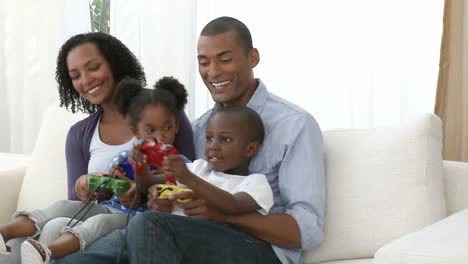 panorama de una familia afroamericana jugando videojuegos en casa