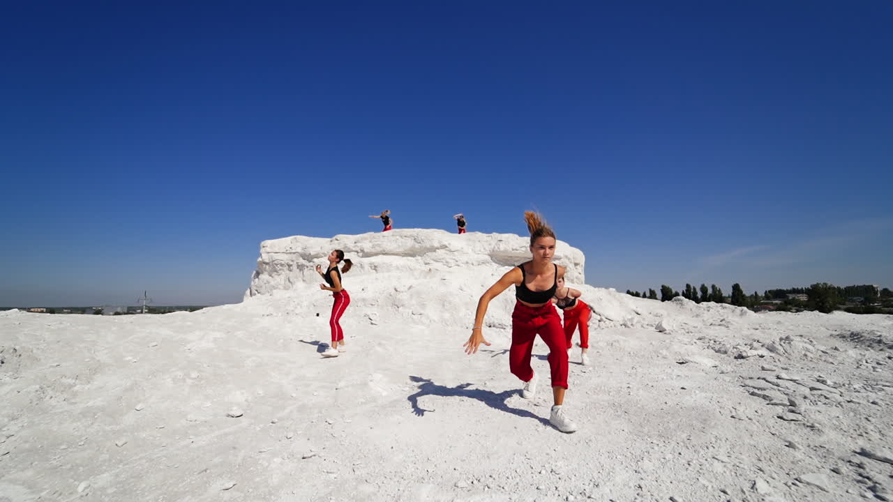 Group of women dancing outdoors on a hill