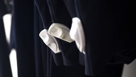 black pants hanging on hangers with security tags in a store