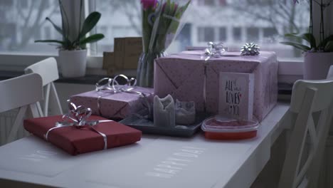 valentines day gifts in red and pink and candy with a love card, handheld wide shot