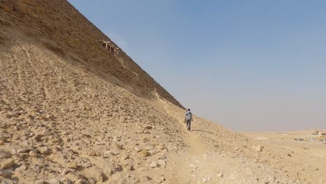 tourist hiking around the ancient egyptian dahshur red pyramid in egypt