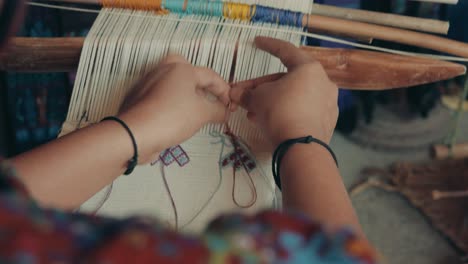 woman weaver at work on her loom in guatemala, central america - high angle, close up