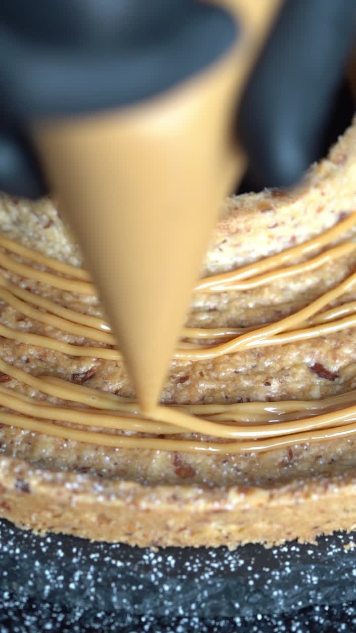 A skilled chef adding smooth caramel sauce to a delicious cake, high angle shot, insert shot