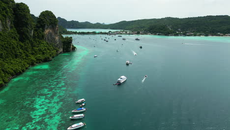 fila anclada de barcos turísticos que visitan la isla de koh phi phi , el paraíso en la tierra en tailandia - sobrevuelo aéreo