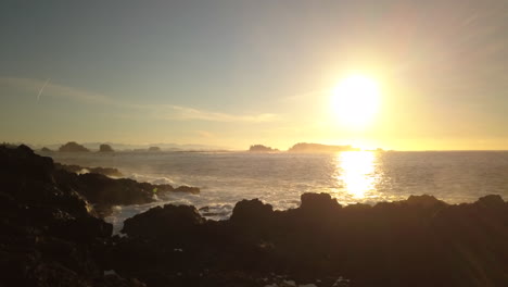 Sunny-calm-ocean-waves-splashing-rocky-shore-of-Ucluelet